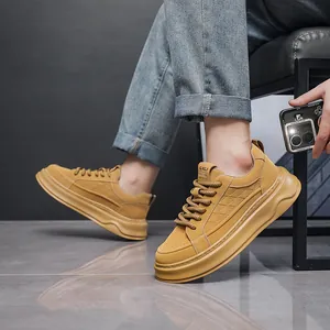 Gedetailleerd overzicht van gele leren herensneakers met dikke zool gedragen door een model