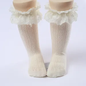 Close-up of white lace ruffle knee high socks for girls with intricate knit patterns