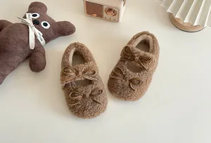 Detail von braunen, flauschigen Kleinkinderschuhen mit doppelten Schleifen-Akzenten.