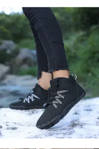 Detail of black fleece-lined winter outdoor snow boots worn on snowy ground for warmth