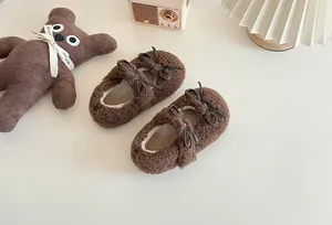 Nahaufnahme brauner Plüsch-Kinderschuhe mit Lederschleife und warmem Innenfutter