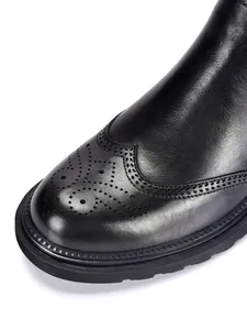 Detailansicht eines schwarzen Herren-Chelsea-Boots aus Leder mit klassischem Budapester Muster