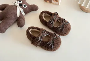 Detail von braunen flauschigen Kinderschuhen mit schicken doppelten Schleifenverzierung