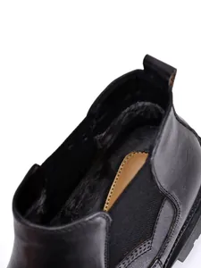 Detailaufnahme schwarzer Leder-Chelsea-Boots mit warmem Plüschfutter