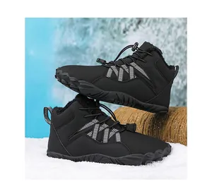 Close-up detail of black fleece-lined barefoot winter boots on a snowy winter background