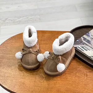 Gemütliche braune Wildleder-Schneestiefel für Kleinkinder mit Schleife, Pompons und Fellfutter.