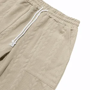 Primer plano de la textura de punto trenzado beige y cordón en pantalones casuales