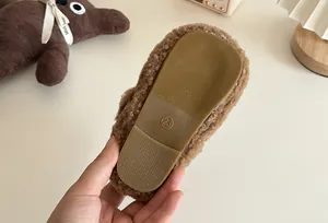 Nahaufnahme der rutschfesten Gummisohle dieser braunen flauschigen Kinderschuhe