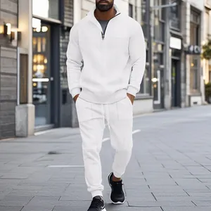 Full-body view of a man in a white textured two-piece sports tracksuit set on a street.