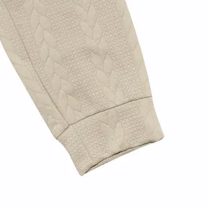 Primer plano de la textura jacquard de punto de cable en puño de sudadera beige