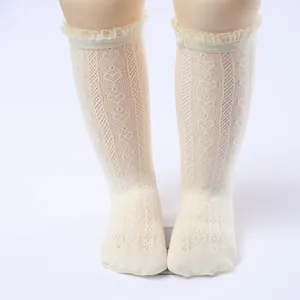 Detailed view of white hollow lace mesh socks with ruffled trim for toddlers