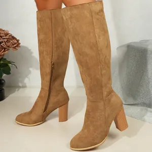 Elegant brown suede knee-high boots featuring a chunky block heel and side zipper closure