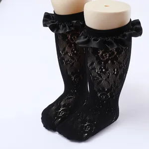 Close-up of black lace Lolita socks with elegant ruffled satin edges for girls.
