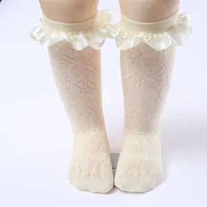 Detailed view of girls off-white lace mesh socks with elegant satin ruffled cuffs
