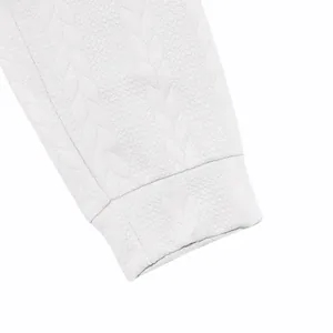 Close-up of white jacquard knit fabric and ribbed sleeve cuff on men's leisure tracksuit