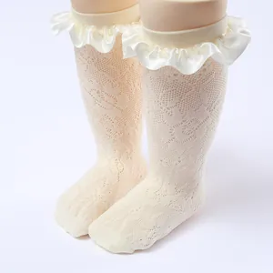 Detail of white girl's princess socks featuring delicate lace mesh and satin ruffles.