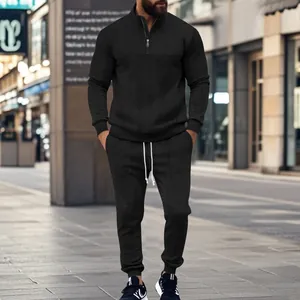 Stylish men's black textured quarter-zip tracksuit set shown in an urban street setting.