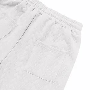 Detalle de pantalones de chándal de jacquard blanco con cintura elástica y bolsillo.