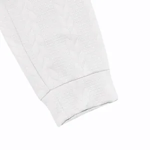 Primer plano de la tela jacquard blanca y detalle del puño de una sudadera para hombre