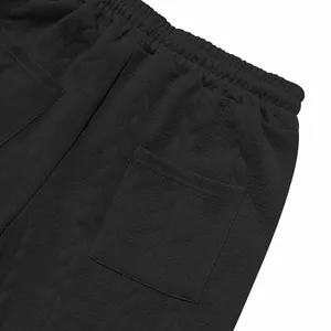 Close-up macro view of black jacquard fabric texture on men's casual trousers
