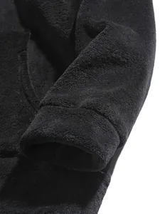 Close-up of the ribbed cuff and soft coral velvet texture of a black fleece hoodie