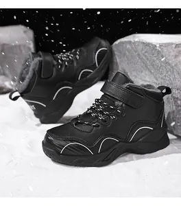 Close-up of boys' black winter sneakers with warm faux fur lining and outdoor snow scene