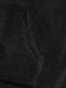 Close-up detail showing the soft coral fleece texture and pocket of black hoodie