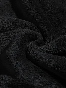 High-resolution macro detail of soft black coral fleece fabric texture for men's hoodies