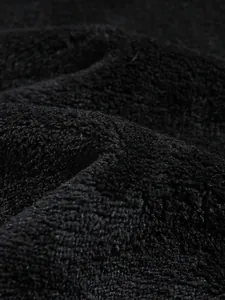 Detailed macro view showing the soft texture of premium black coral fleece fabric material