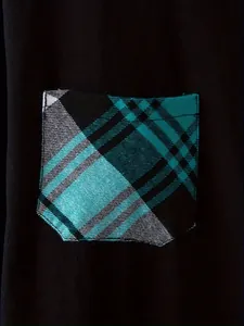 Macro close-up view of the teal plaid pattern pocket detail on a black casual shirt