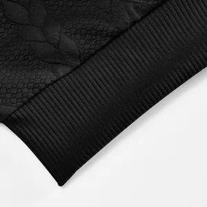 Detalle de textura de punto jacquard negro y puño acanalado en sudadera deportiva para hombre