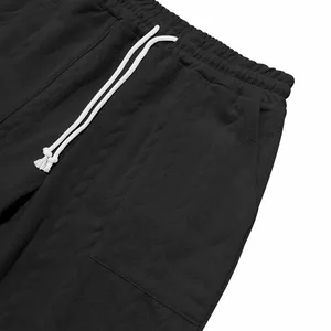 Primer plano del tejido jacquard negro en joggers con cintura elástica de cordón