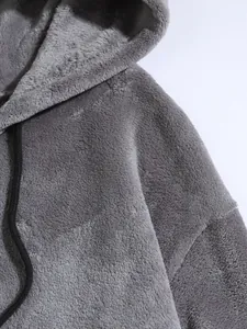 Close-up of grey coral fleece hoodie showing soft plush texture and black drawstring.