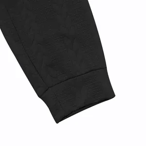 Detalle de cerca de sudadera negra para hombre con textura jacquard de patrón de hojas intrincado