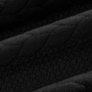 Primer plano de tejido de punto jacquard negro con patrón de diamantes para sudadera
