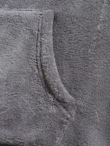 Close-up detail of soft grey coral fleece fabric and pocket stitching on hoodie