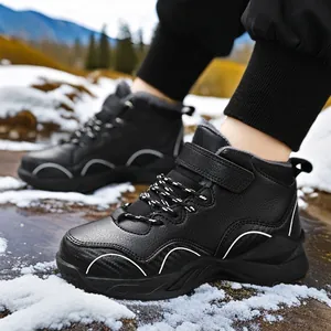 Children's boys black leather winter sneakers with warm fleece lining and snow outdoors