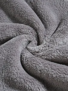 Close-up macro view of high-quality grey coral fleece fabric for warm winter hoodies.