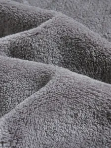 Close-up detail of soft grey coral fleece fabric showing plush texture and density.
