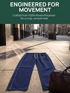 Close-up of navy blue woven straight-leg trousers with white side piping on a city street