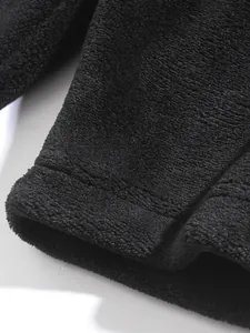Nahaufnahme der schwarzen Korallenvlies-Stoffstruktur und der Saumnaht an Sportshorts
