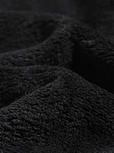 Macrodetail van de zachte zwarte koraalvlies-stoftextuur van de winterhoodie voor heren.