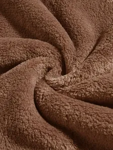 Macro detail of soft brown coral fleece fabric showing plush texture and folds.