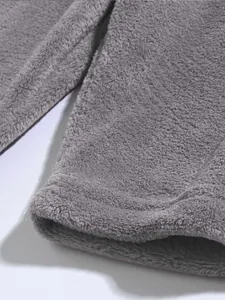 Nahaufnahme von grauen Korallenfleece-Herrenshorts mit weicher Plüschstruktur und Saum.