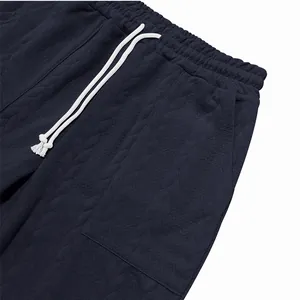Primer plano de pantalones deportivos azul marino con textura jacquard y cordón blanco