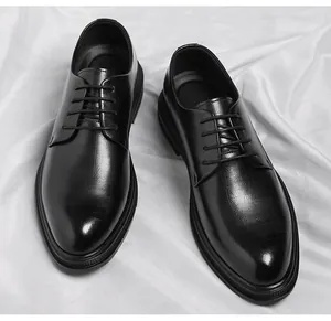 Detailed top view of men's black pointed-toe business leather shoes on white satin