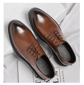 Top-down view of men's elegant brown textured leather dress shoes on white fabric background