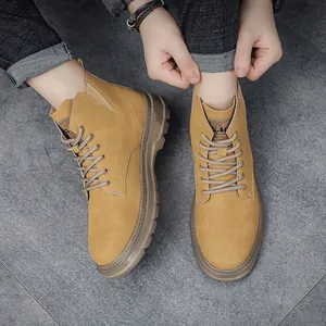 Top-down view of mustard yellow vintage work boots worn with denim jeans on a tiled floor.