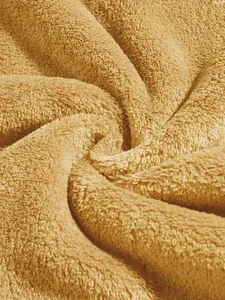 Macro detail view showing the soft and thick texture of camel coral fleece fabric