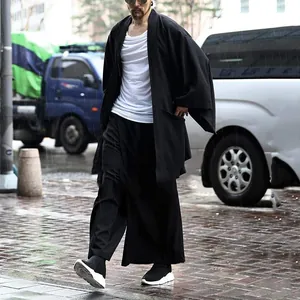 Dettaglio cardigan nero uomo con maniche a pipistrello per un look streetwear alla moda